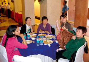 Delegates seated around a table with snacks.