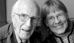 Black and white headshot of two people smiling at the camera.
