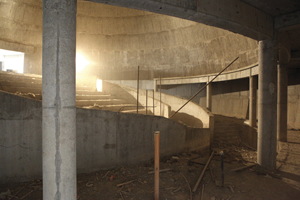 Interior of an oval concrete space under construction.