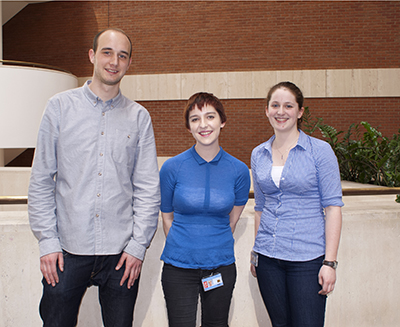 Three colleagues standing in the British Library foyer.