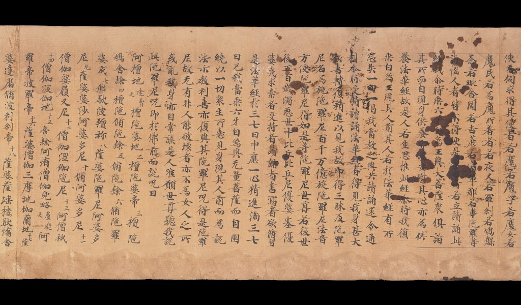 A Chinese scroll with smudgy black marks over the writing on the right hand side.