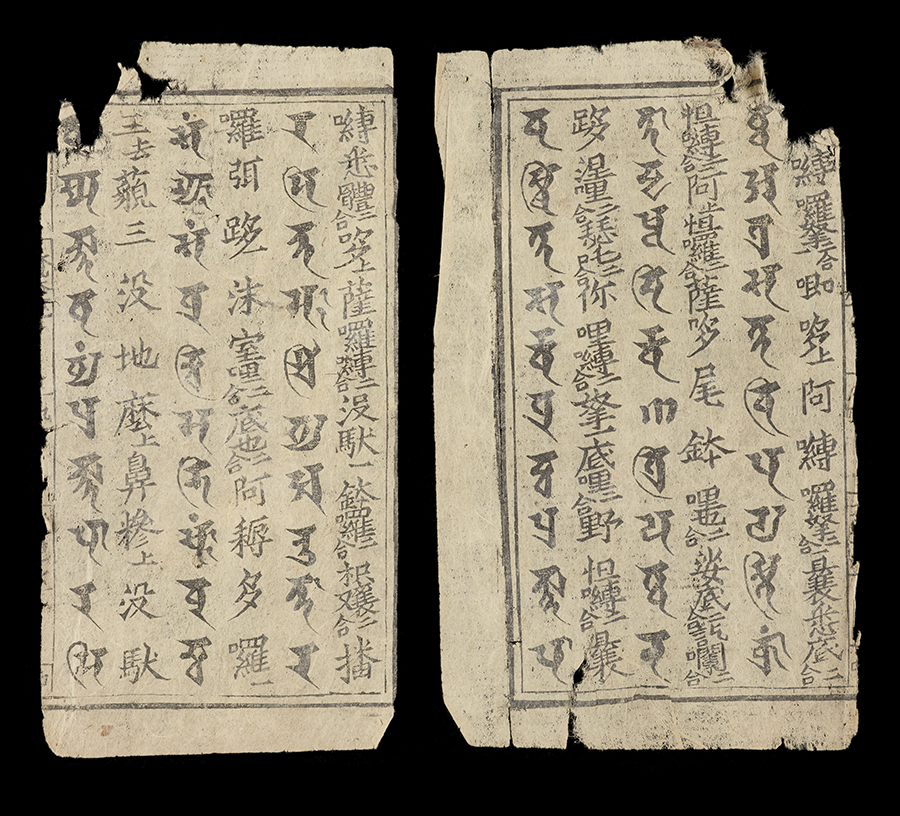 Paper pages printed with Brahmi and Chinese characters.