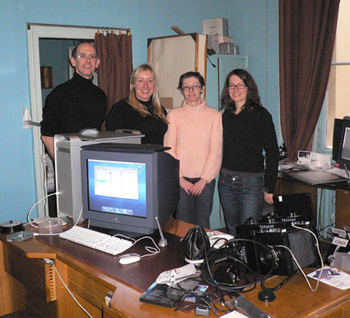 Four colleagues in an office with a lot of computer equipment.