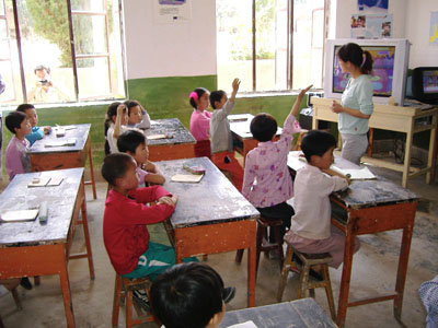 Children in a Chinese classroom answering a teacher's question.