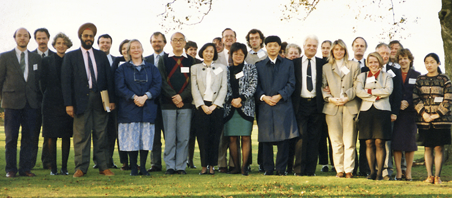 Group of conference delegates posed outdoors, colour photograph.