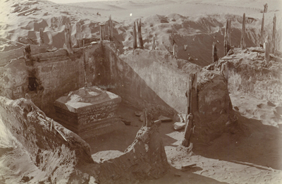 Archaeological site showing the walls of an excavated building. Historic sepia photograph.