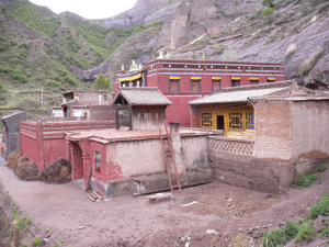 A red-painted building complex in a mountainous area.