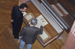 People viewing manuscripts, seen from above.