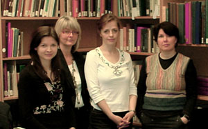Four colleagues photographed in front of a bookshelf.