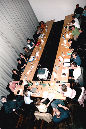 A large number of colleagues sitting around tables at a workshop.