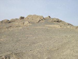 Ruins of a building on a bare hill, modern colour photograph.