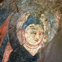 Detail of a wall painting showing the face of a Buddha.
