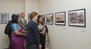 Colleagues looking at photographs displayed in an exhibition. 