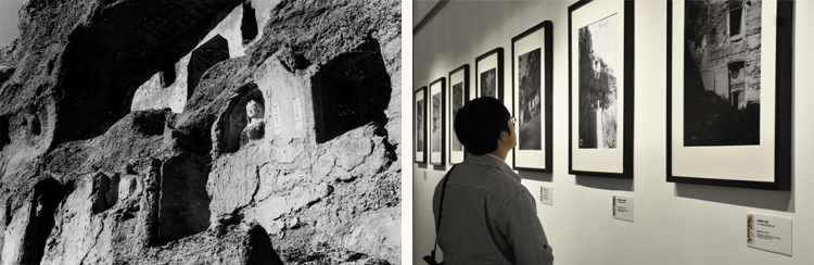 Composite of a historical black and white photograph of caves carved into a cliff face, and a modern photograph of someone looking at these photographs in an exhibition.