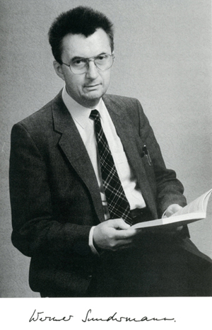 Posed photograph of Werner Sundermann with open book, black and white.