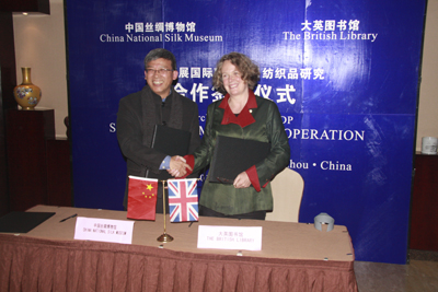 Susan Whitfield and Zhao Feng shaking hands after signing a Memorandum of Understanding between IDP and the Chinese National Silk Museum.