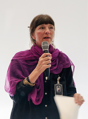Headshot of Eva Myrdal with a microphone. 