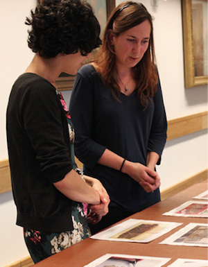 Colleagues looking at images laid out on a desk. 