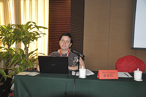 Irina Popova at a desk, presenting a paper at a conference. 