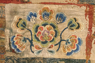 Brightly coloured embroidered textile.