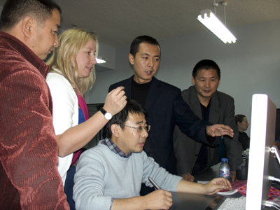 Colleagues gathered around a computer screen.