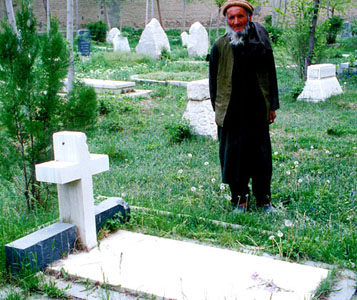 Mr Rahimullah, the graveyard's guardian, standing by Stein's grave. 