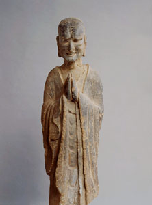 Small state of a monk with hands held together in prayer or greeting. 