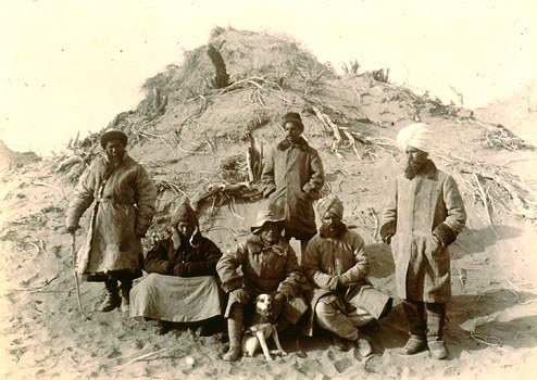 A group of men in the desert. Historic black and white photograph.