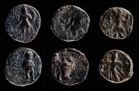 Six old coins with human figures on their faces photographed against a black background.