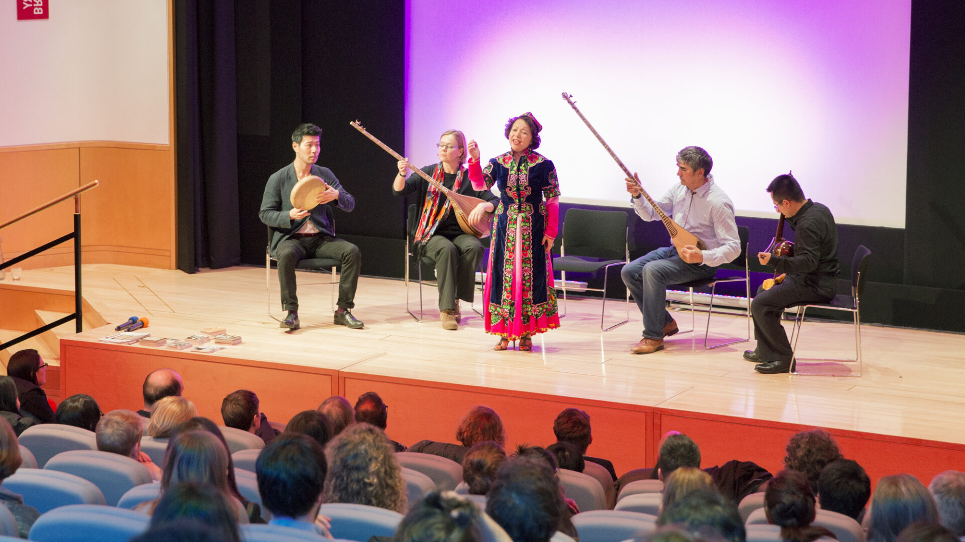 Photograph of a performance using traditional instruments on a stage in front of an audience.